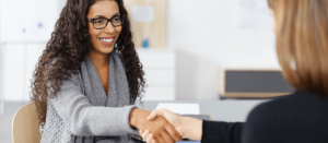admissions-min Female student shaking hands with admissions representative.
